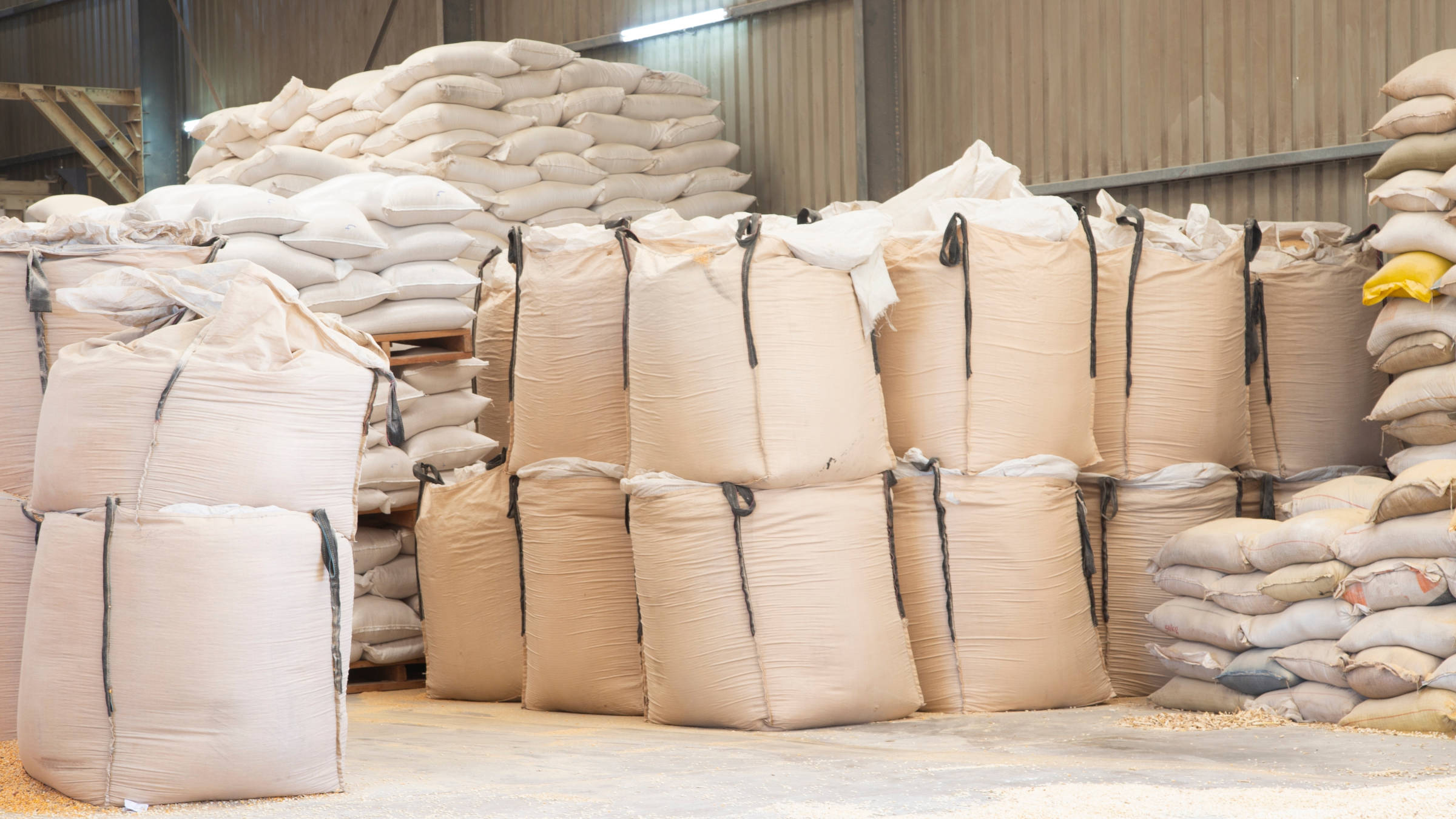 Big bags and 50 kg sacks of grain stacked in a warehouse before loading